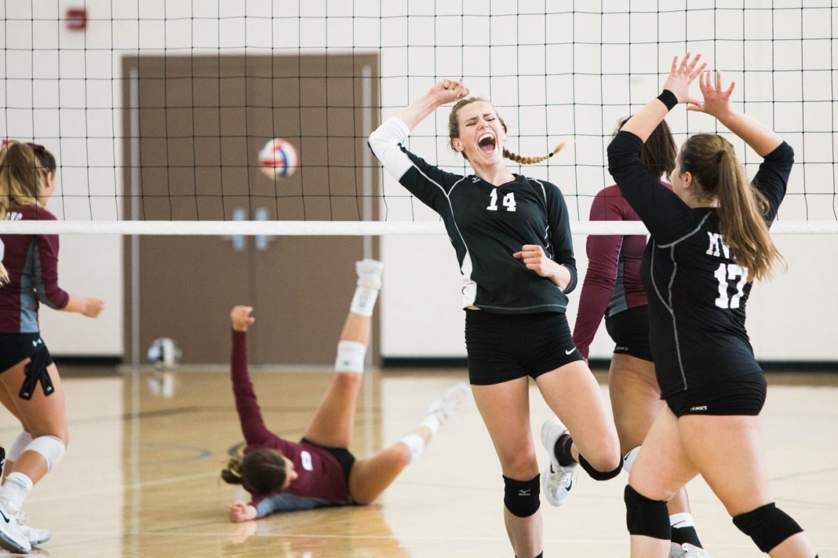 Volleyball players celebrating | Featured Image for the Can mouthguards strengthen teeth blog by Denture Health Care.