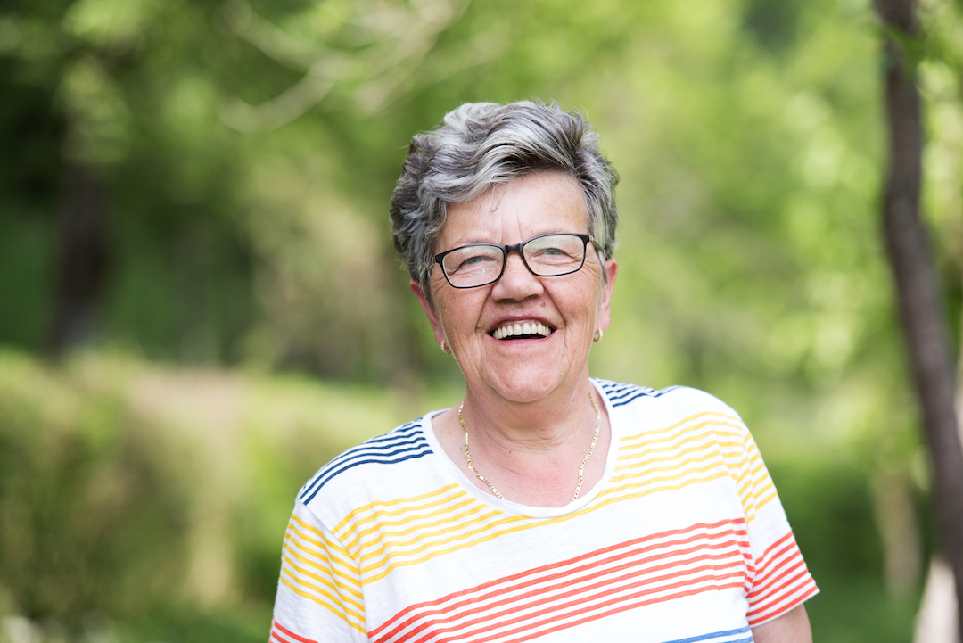 Elderly lady smiling at the camera | Featured Image for the Do dentures ever feel normal blog by Denture Health Care.