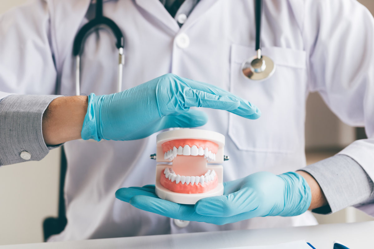 Dentist holding dentures | How to care for dentures - dos and dont's