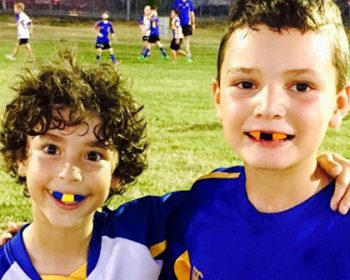 Two kids smiling wearing mouthguards | Featured image for the Custom Mouthguards Brisbane from Denture Health Care.