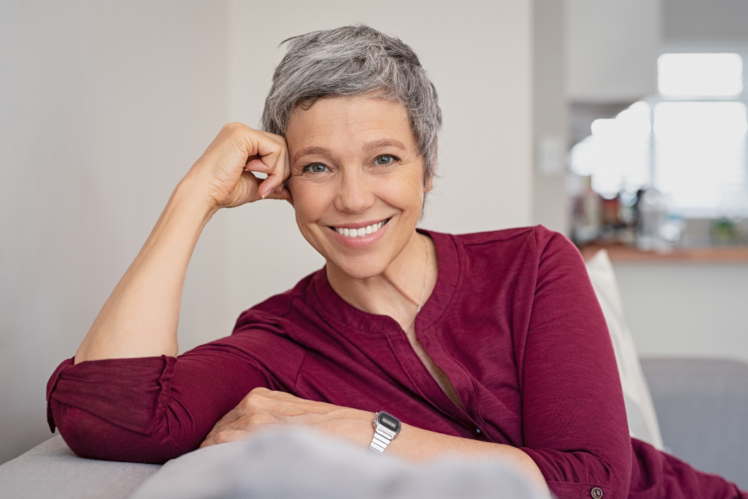 Smiling woman in a red top | Featured image for The Denture Recall page from Denture Health Care.