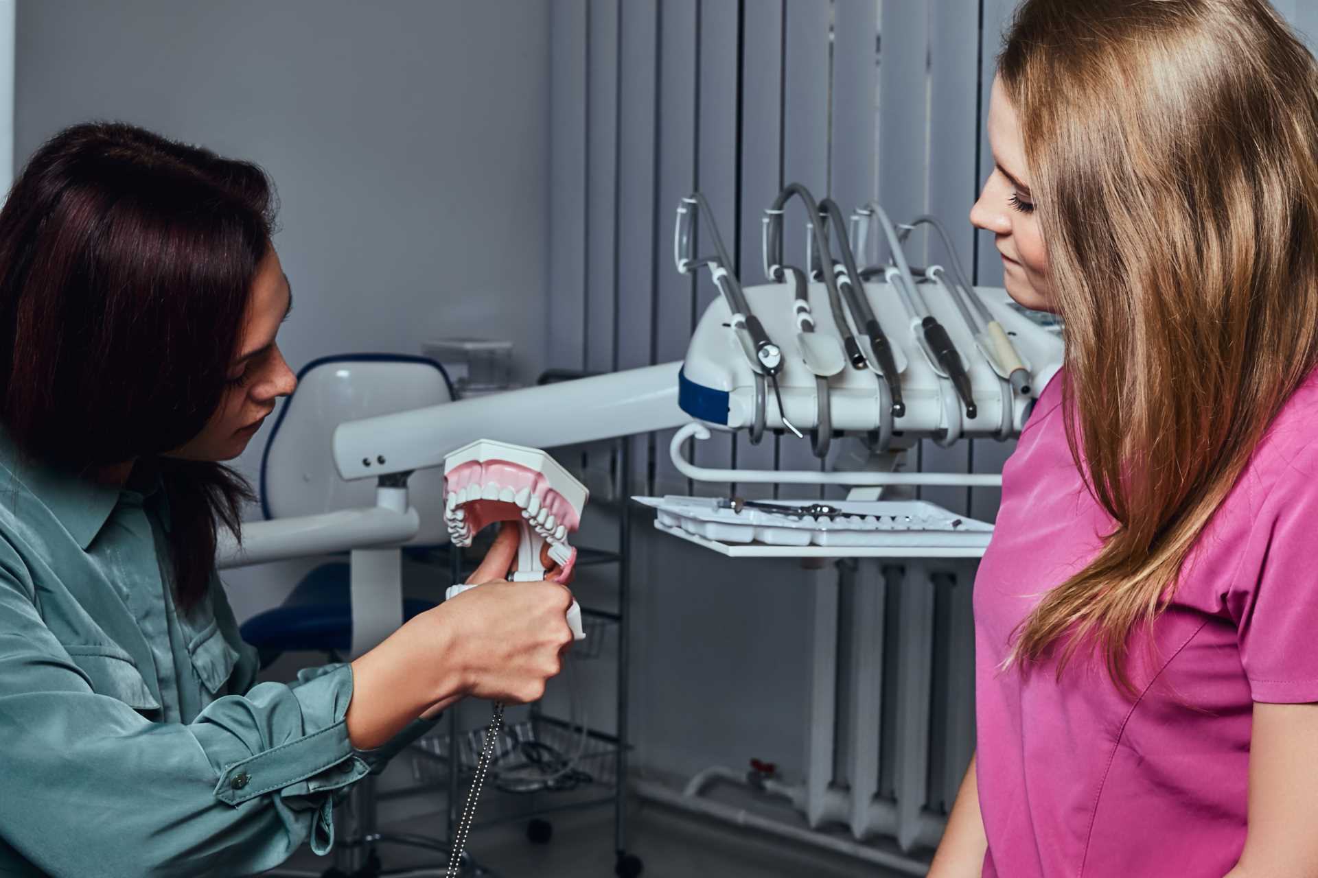 Dentist showing a patient a set of dentures | Featured image for Denture Health Care’s Dental Implant Infections blog.